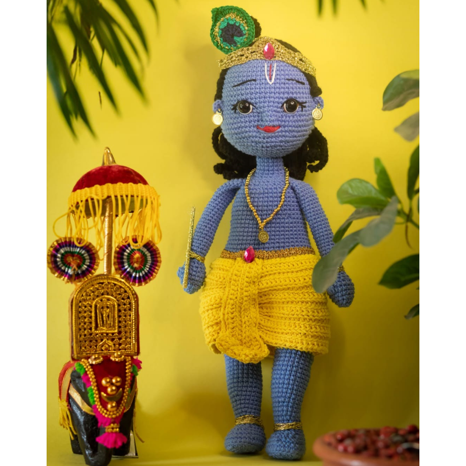 an amigurumi krishna doll in yellow background