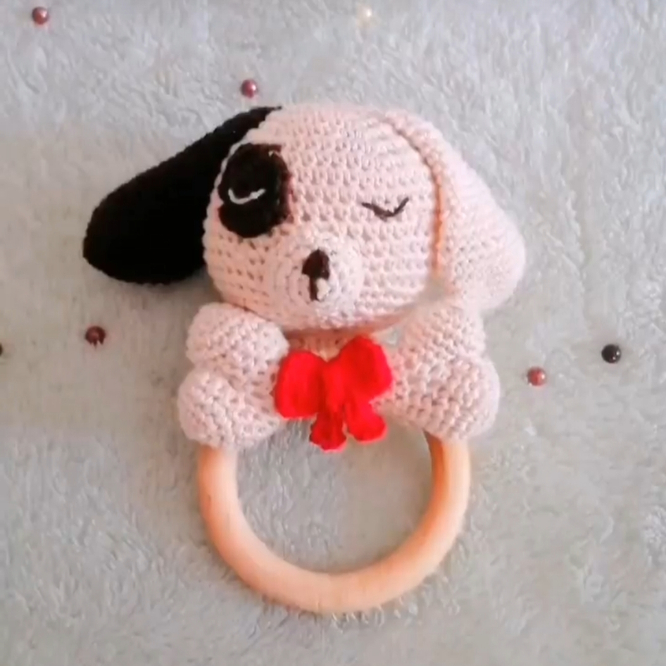 a crocheted dog rattle in a pastel background