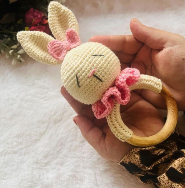 bunny rattle with pink ruffles in a hand