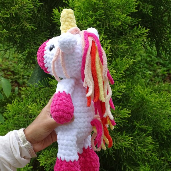 Crochet amigurumi handmade unicorn plushie in pink and white combination back view of mane