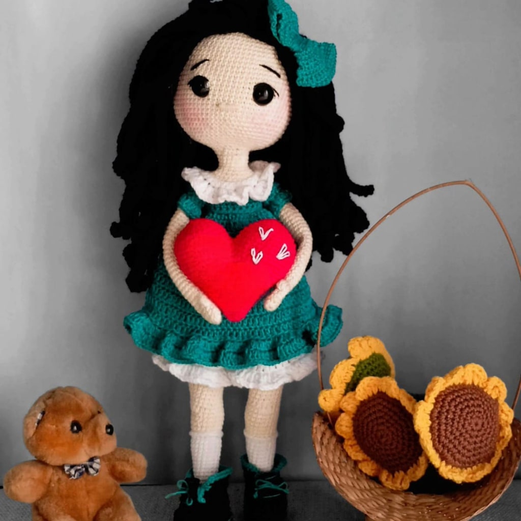 crochet doll in blue dress with heart in hand