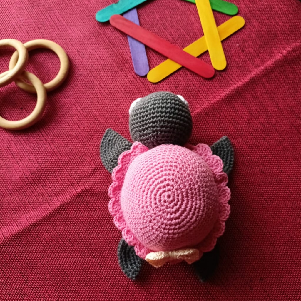 amigurumi pink turtle on a red background