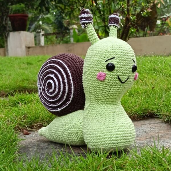 a cute snail toy in a garden